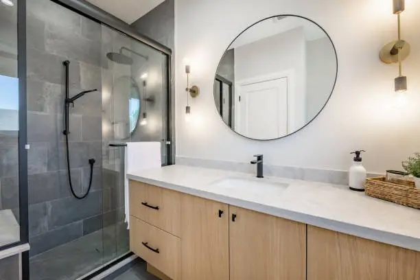 modern bathroom with round mirror -how long does a bathroom remodel take