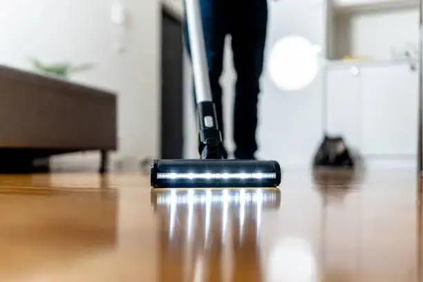 Vacuum cleaner with LED lights cleaning a polished hardwood floor. -best floor cleaner