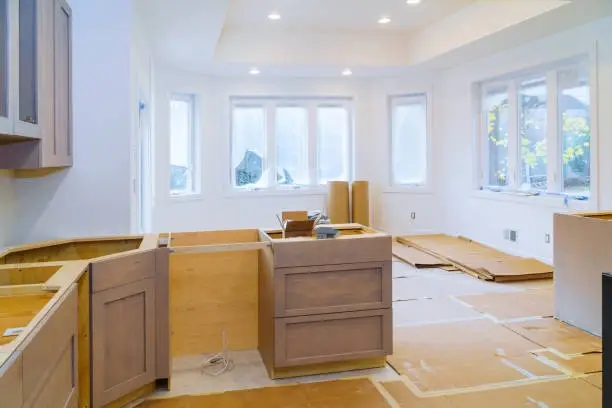 Kitchen renovation in progress with unfinished cabinets and flooring. -home addition contractor