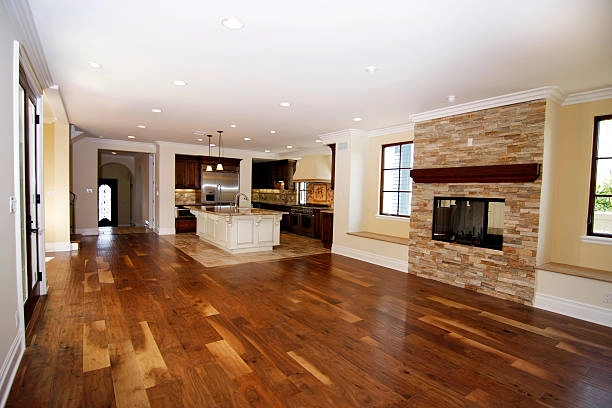Spacious open-concept home with hardwood floors and modern kitchen. -floor repair services- Elite Remodels